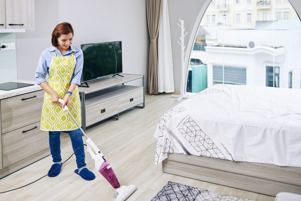 Housewife vacuum cleaning floor