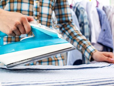 Closeup of woman ironing clothes on ironing board
