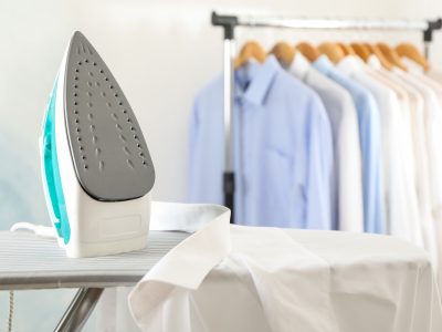 Iron and shirt on ironing board, space for text
